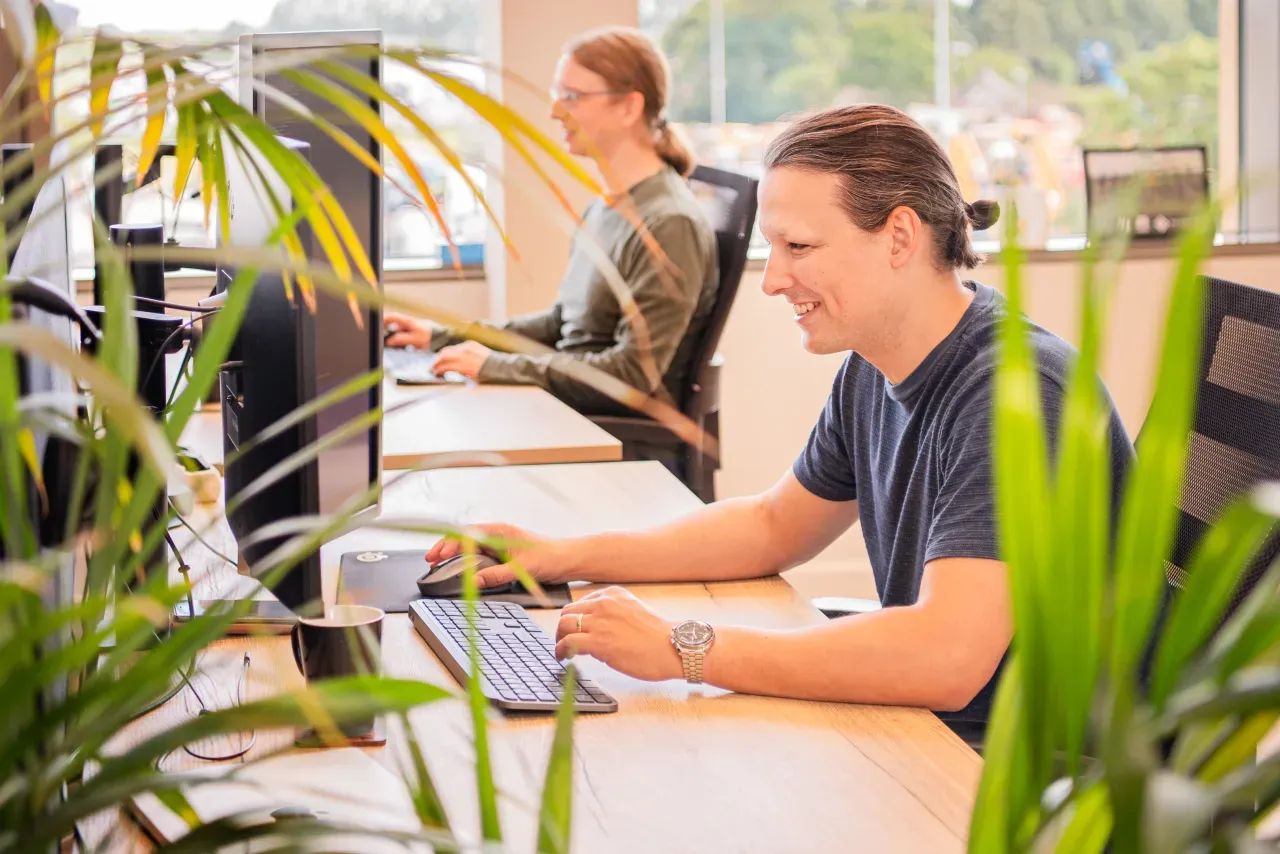 Twee ontwikkelaars van Meierij IT werken aan bedrijfssoftware op hun werkplek
