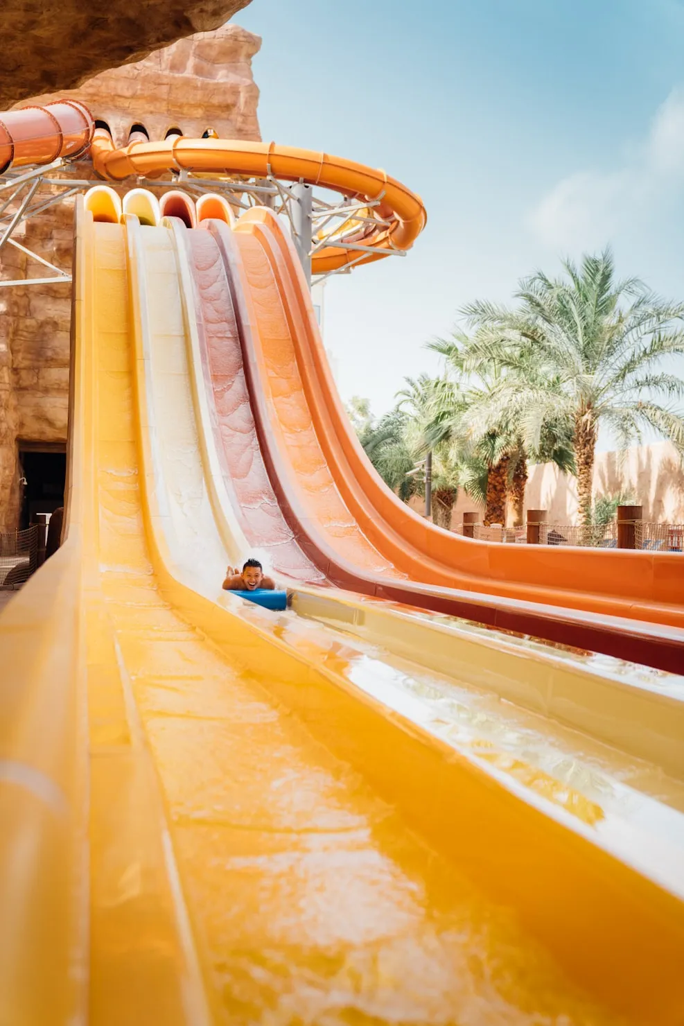 Kind glijdt van een meerbaans waterglijbaan in een waterpark